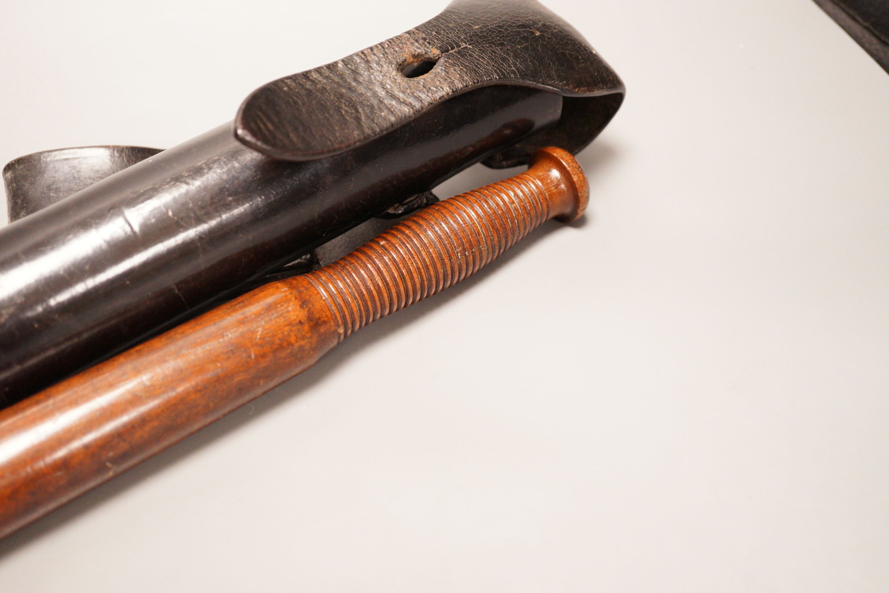 A 19th century constabulary truncheon together with associated spring loaded leather case